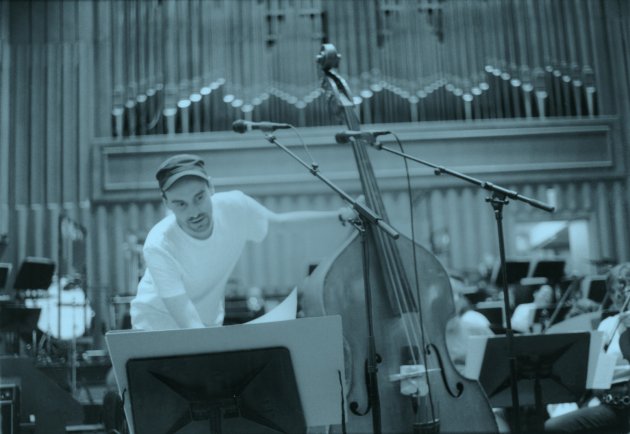 Henrik von Holtum, Kontrabass, Orchester, Orgel, Mikrofon, Notenständer, Sepia, weißes T-Shirt, grüne Mütze